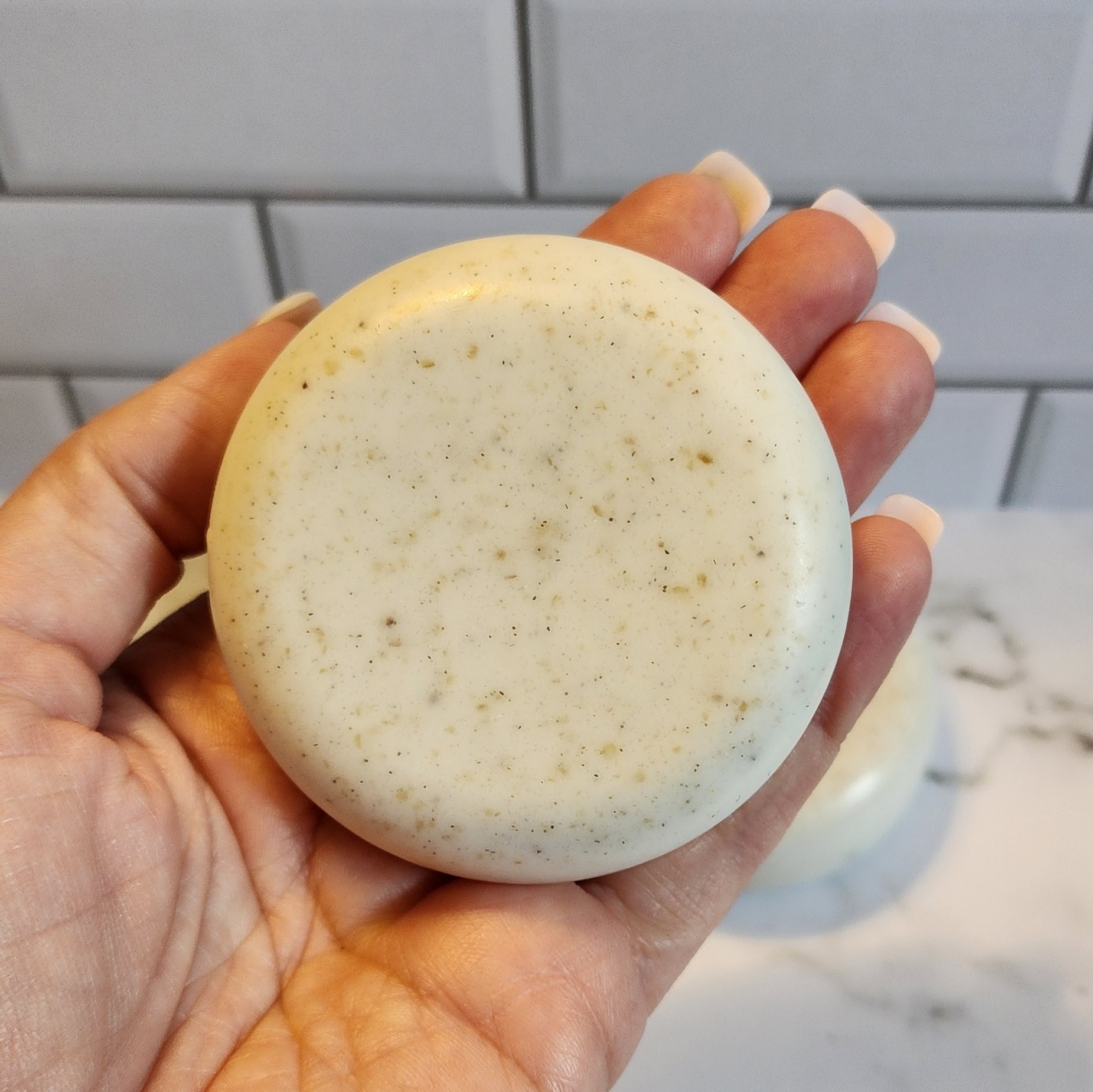 An oatmeal and bentonite clay bar of soap with pumice exfoliating powder.